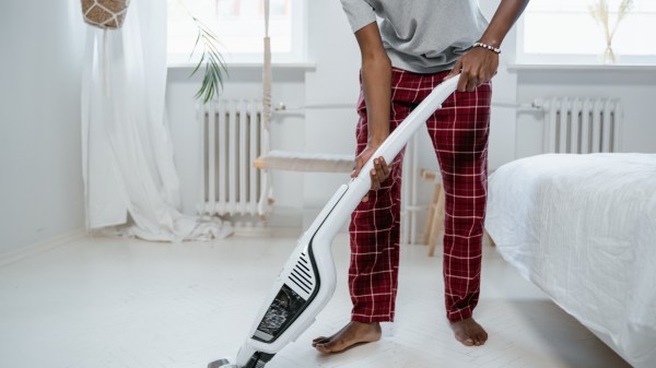 Barefoot man using vacuum cleaner
