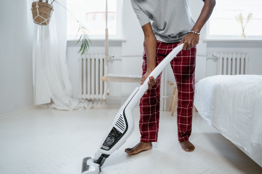 Barefoot man using vacuum cleaner