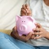 Girl and father putting a coin into piggy bank