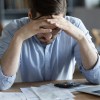 Man pondering bankruptcy paperwork