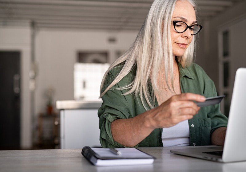 Woman makes credit card balance transfer to pay off debt