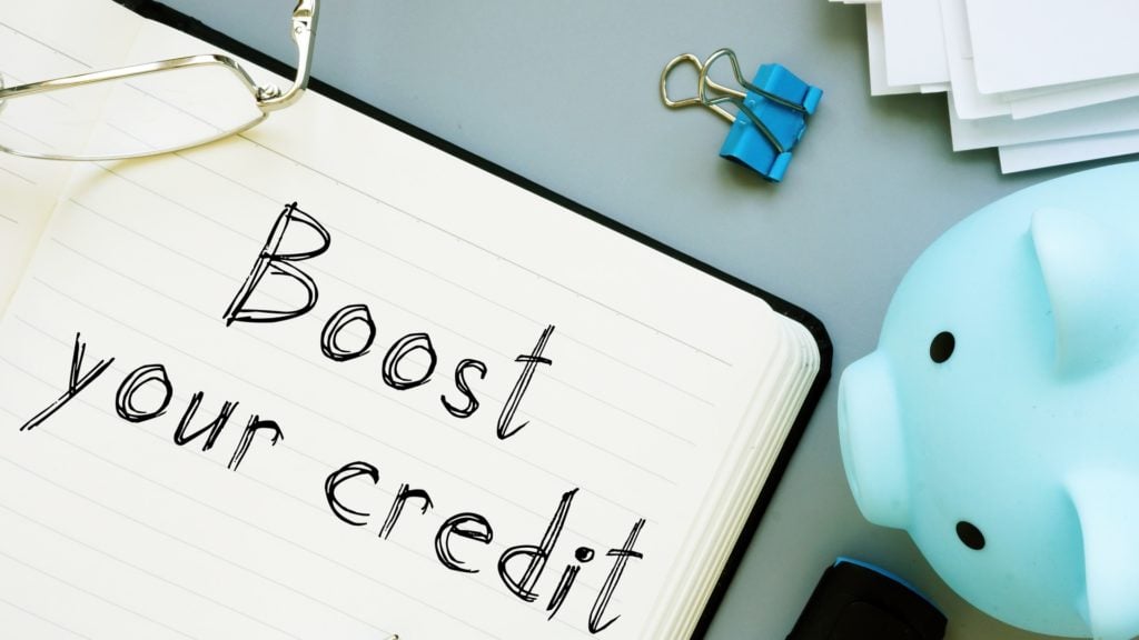 A piggy bank and a whiteboard reading boost your credit guide readers toward a 700 credit score.