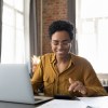 A young woman looking at her finances while sitting at a dining table