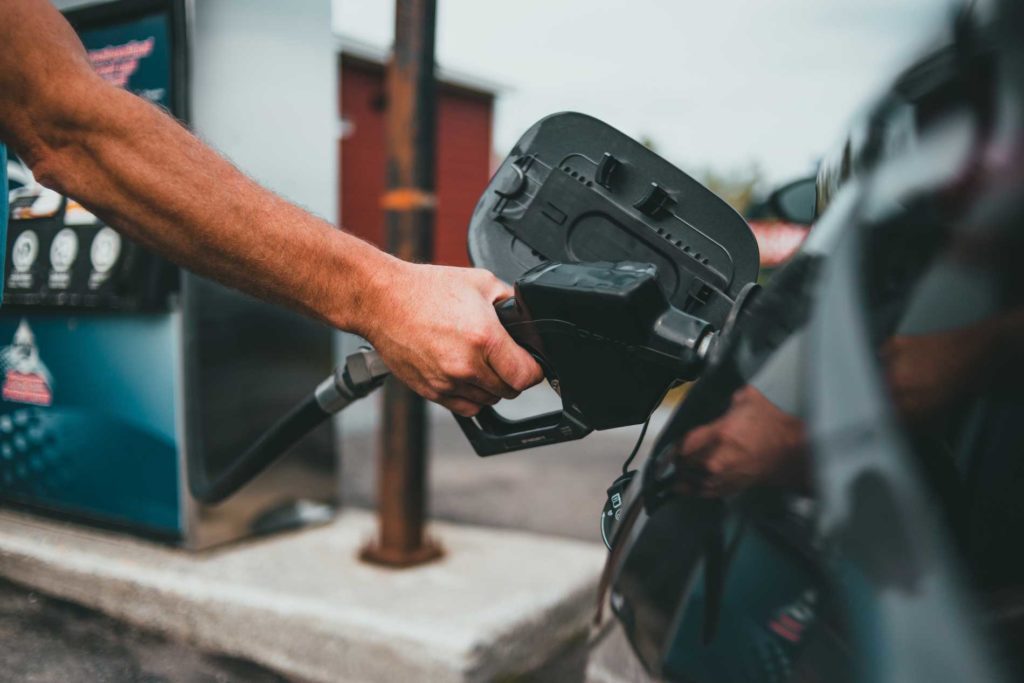 Pumping gas amid high prices per gallon, prompting a discussion on budgeting