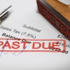 Rubber stamp with the text past due over an invoice document.