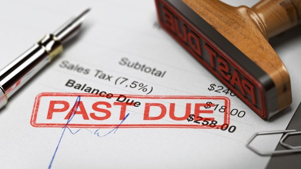 Rubber stamp with the text past due over an invoice document.
