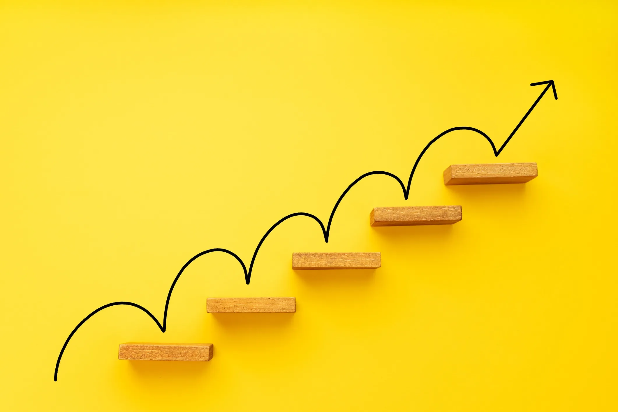 Rising arrow on staircase on yellow background