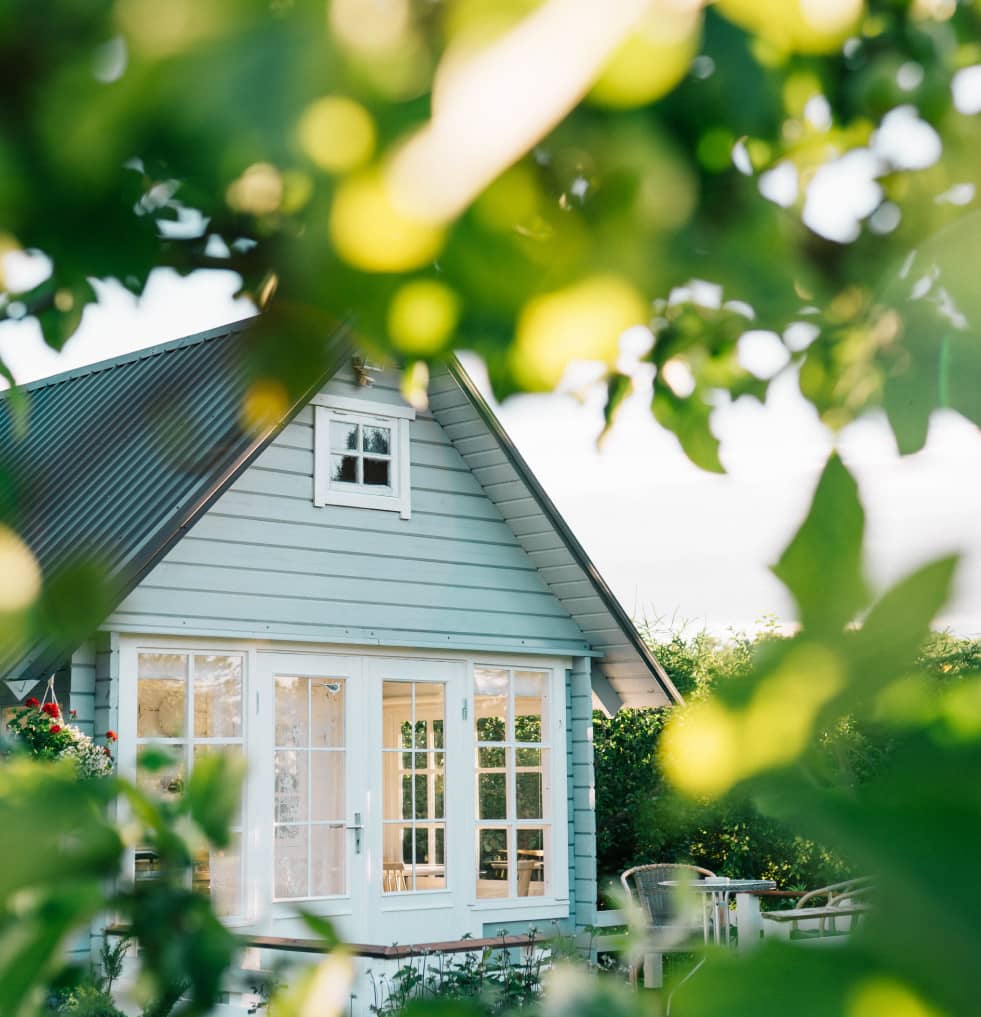 Light blue house and light filtering through foliage.