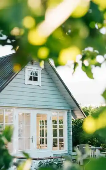 Light blue house and light filtering through foliage