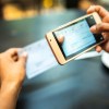 Woman depositing check by phone in a cafe