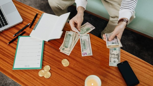 A person budgeting money in a coffee table