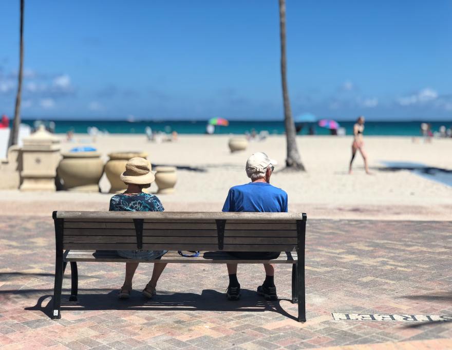 Retired couple sits on bench