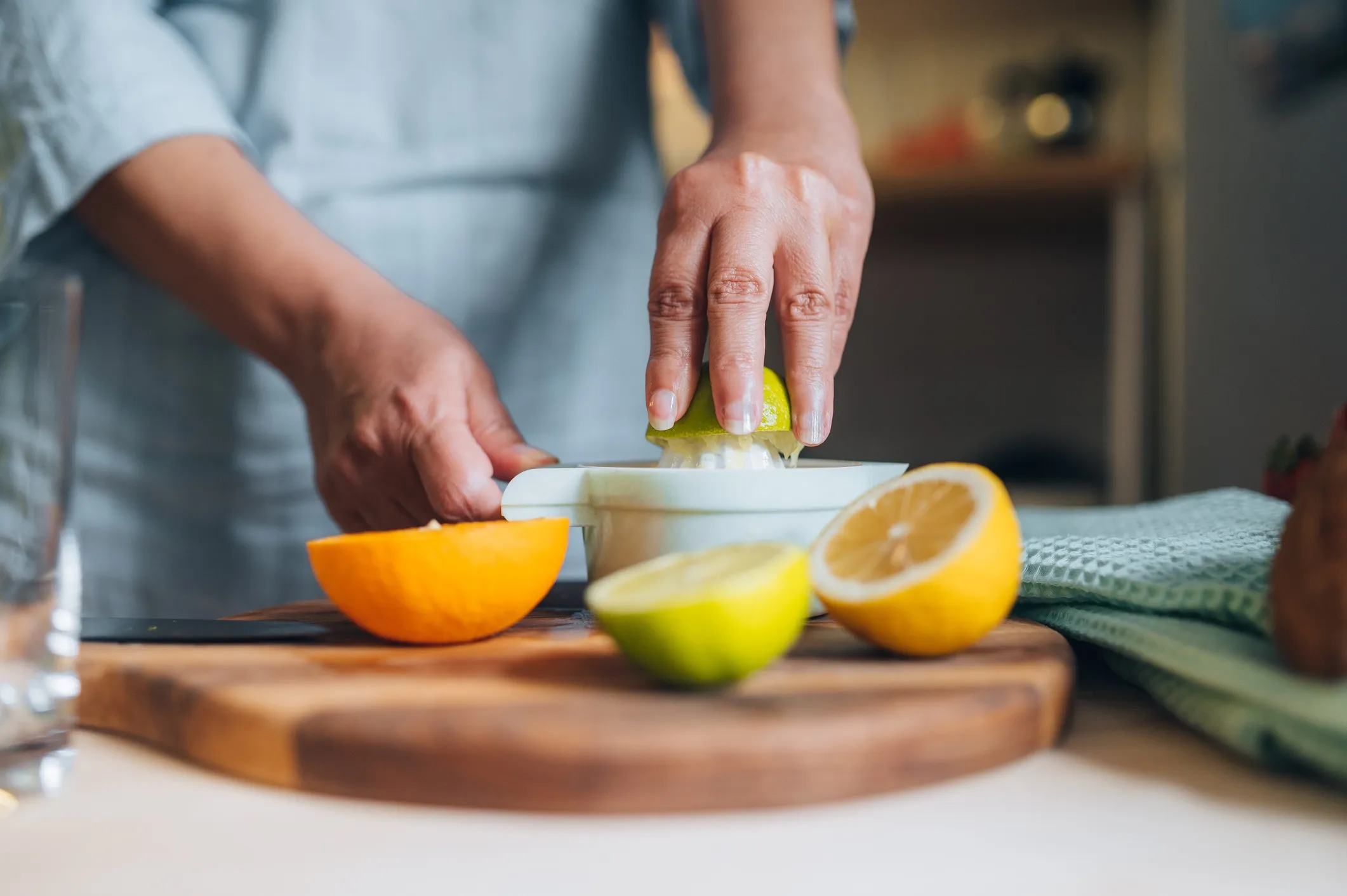Woman squeezing a lime at a kitchen counter