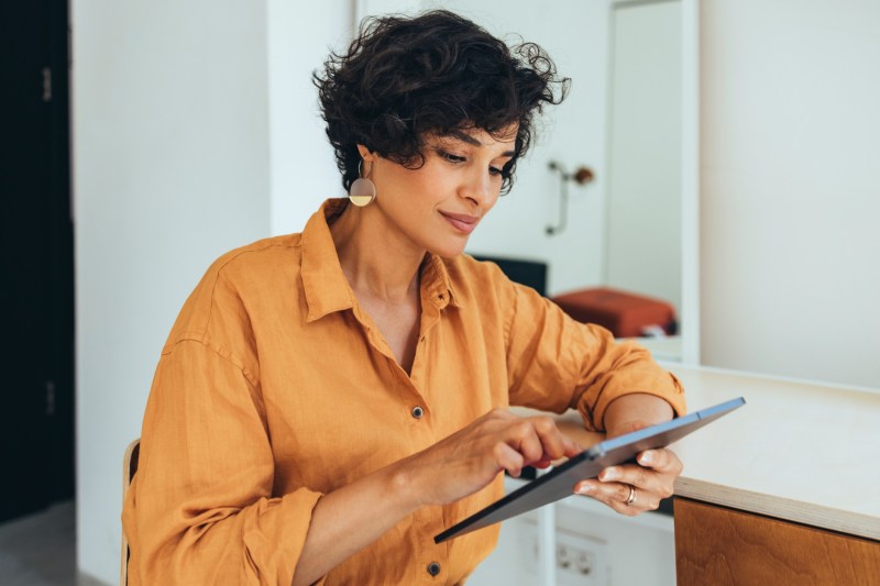 A woman checking her credit on her tablet