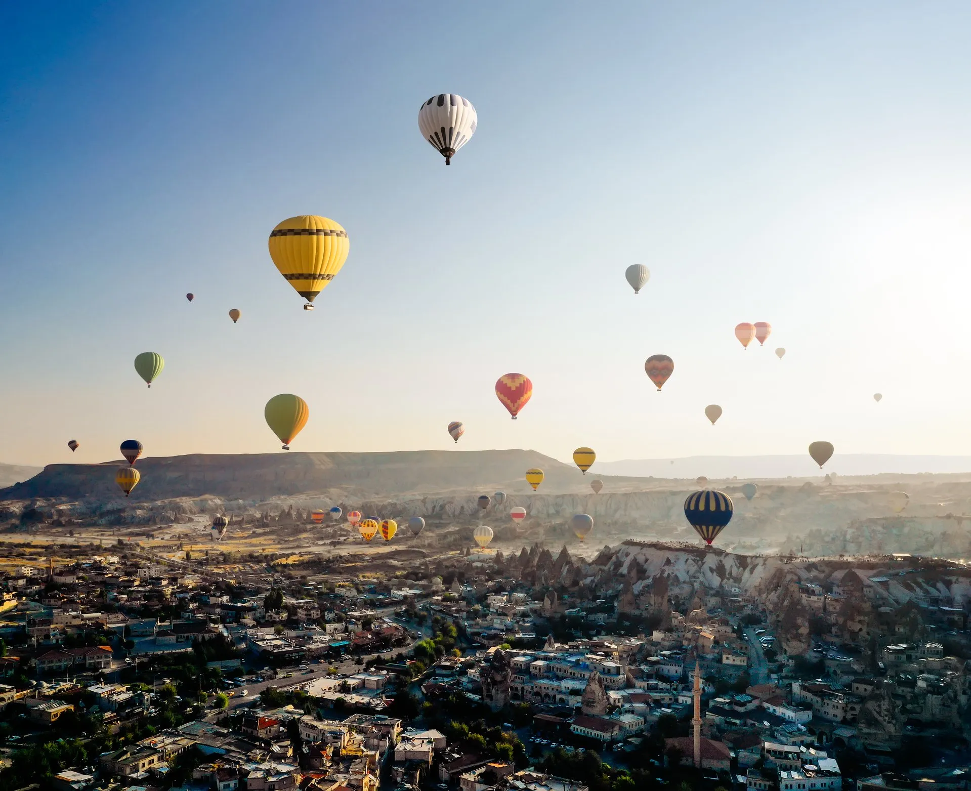 Aerial view of hot air balloons flying over Cappadocia at sunrise